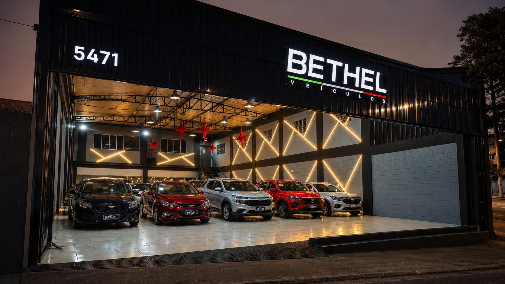 Fachada da Bethel Veículos na Av. São Miguel ao anoitecer